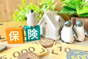 保険の文字ブロックとペンギンの置物、10円硬貨が並んだ社会保険料の写真