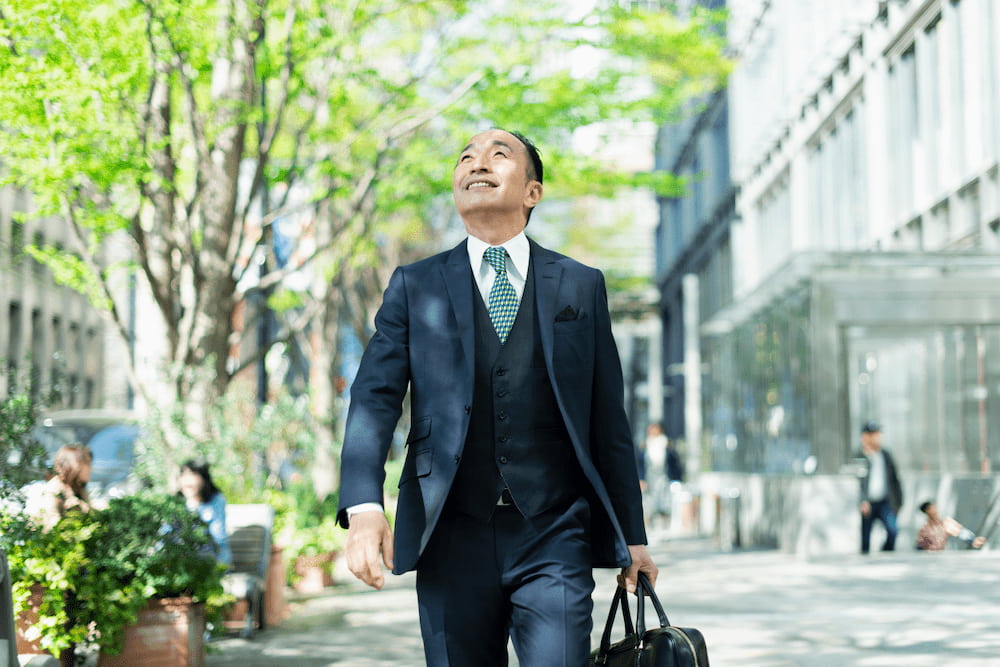 スーツを着て出勤するシニアビジネスマン。高年齢雇用継続給付の対象となる60代の働く姿