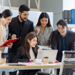 多国籍のビジネスパーソンがオフィスで協働する様子。外国人労働者230万人時代の職場風景