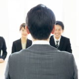 採用面接の様子。求職者の背中越しに複数の面接官が向き合っている