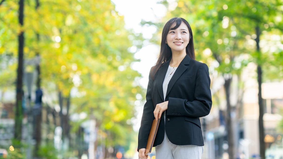 書類を持って歩くビジネスウーマン。女性活躍推進のイメージ