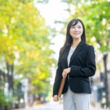書類を持って歩くビジネスウーマン。女性活躍推進のイメージ