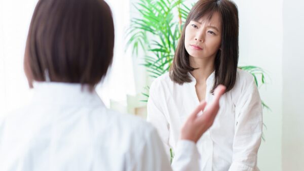 職場で真剣に相談・対話する女性社員たち。尊厳を大切にしたコミュニケーションのイメージ