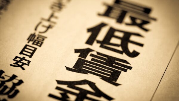 「最低賃金」「引き上げ幅目安」の見出しが並ぶ新聞紙面（令和8年度最低賃金改定のイメージ）