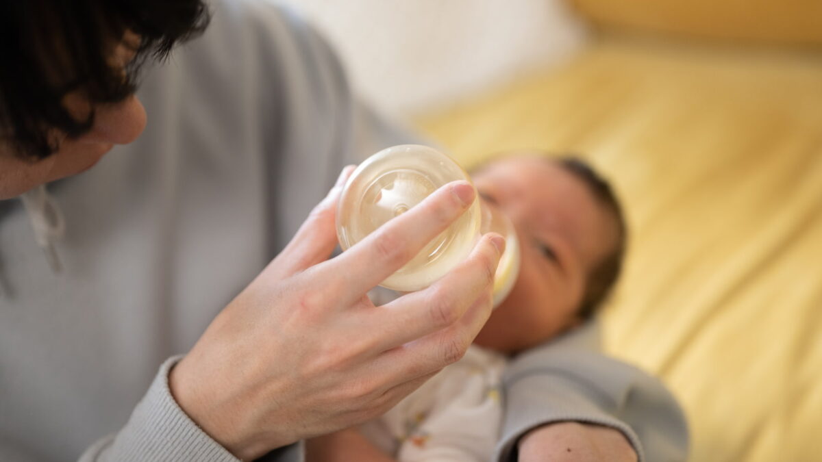 哺乳瓶でミルクをあげる親と赤ちゃん(夫婦で取り組む「共育て」のイメージ)