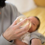 哺乳瓶でミルクをあげる親と赤ちゃん（夫婦で取り組む「共育て」のイメージ）